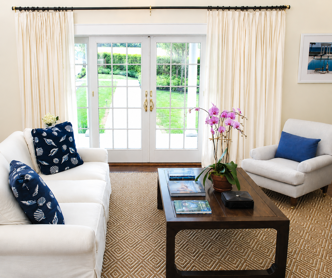 Hamptons living room with white seating, orchid, and garden view
