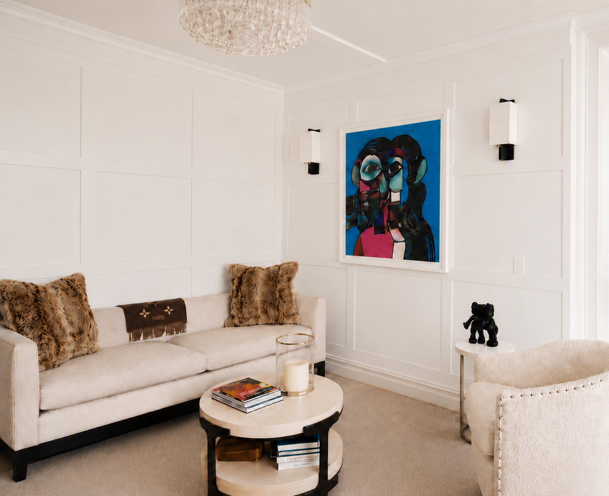 Formal sitting room at CPW with white sofa, abstract art, and tiered coffee table